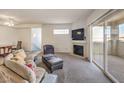 Comfortable carpeted living room featuring a fireplace, television, and a sliding door to the outside at 6909 Cobre Azul Ave # 202, Las Vegas, NV 89108