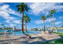 Beautiful community pool with sandy beach area, tall palm trees, and clear blue water, perfect for recreation at 7624 Nocturne Ct, Las Vegas, NV 89128