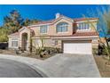Attractive two-story home showcasing a red tile roof, desert landscaping, and an attached two-car garage at 7624 Nocturne Ct, Las Vegas, NV 89128