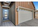 Exterior view of a modern home featuring a garage, front door and brick driveway at 829 Stepney Pl, Henderson, NV 89011