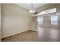 Open dining room with wood floors, neutral paint, and contemporary chandelier at 20 E Serene Ave # 304, Las Vegas, NV 89123