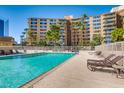 Beautiful outdoor pool area with lounge chairs and lush landscaping near the building at 205 E Harmon Ave # 704, Las Vegas, NV 89169