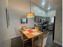 Bright dining area featuring a wooden table set, modern light fixture and grey-toned cabinets at 2052 Jade Creek St # 202, Las Vegas, NV 89117