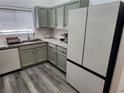 Modern kitchen with grey-toned cabinets, granite countertops, stainless appliances, and wood-look floors at 2052 Jade Creek St # 202, Las Vegas, NV 89117