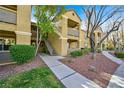 Multi-story condo building featuring well-maintained landscaping, sidewalks and inviting curb appeal at 2300 E Silverado Ranch Blvd # 1119, Las Vegas, NV 89183
