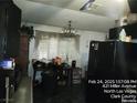 The kitchen boasts dark cabinetry, a chandelier, and natural light coming from the window at 421 Miller Ave, North Las Vegas, NV 89030