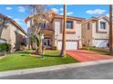 Charming two-story home featuring a well-maintained lawn and a red driveway at 4450 Zev Ct, Las Vegas, NV 89121