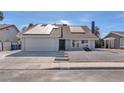 Charming single-story home showcasing solar panels, a two car garage, and low maintenance desert landscaping at 4571 Mcmillan Rd, Las Vegas, NV 89121