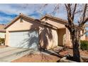 Inviting single-story home with a well-manicured yard, a two-car garage, and a welcoming entrance at 5128 Canary Island Ct, North Las Vegas, NV 89031