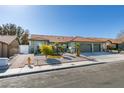 Well-manicured single-story home with a tile roof, two-car garage, and verdant landscaping at 9031 W Cherokee Ave, Las Vegas, NV 89147