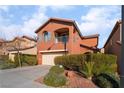 Charming two-story home with a balcony, a two-car garage, and mature landscaping in front yard at 10858 La Florentina Ave, Las Vegas, NV 89166