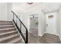 Bright entryway with wood-look tile floors, staircase with railing, and views into a living space at 10963 Mount Goyer St, Las Vegas, NV 89141