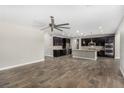 Open floor plan living room with a large fan, wood-look tile flooring, and modern kitchen at 10963 Mount Goyer St, Las Vegas, NV 89141