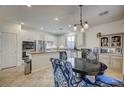 Modern kitchen with stainless steel appliances, granite countertops, white cabinets, and a stylish dining area at 10990 Mountain Willow St, Las Vegas, NV 89179
