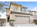 Two-story tan home featuring a two-car garage and nicely-maintained landscaping at 137 Rosa Rosales Ct, North Las Vegas, NV 89031