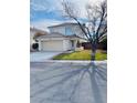Charming two-story home with a well-kept lawn, attached garage, and mature tree at 1960 Verbania Dr, Las Vegas, NV 89134