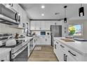 Well-appointed kitchen with modern appliances, white cabinets, and an island with stylish pendant lighting at 2211 Frontier Ave, Las Vegas, NV 89106