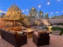 A beautiful outdoor patio is warmly lit with string lights above comfortable seating and a decorative fountain at 2436 Chateau Napoleon Dr, Henderson, NV 89044