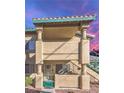 Beige two-story condo with desert landscaping and a wrought iron gate enclosing the front patio at 328 S Buffalo Dr # 101, Las Vegas, NV 89145