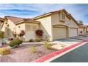 Exterior shot of a home showing the two car garage, desert landscaping, and red-tiled roof at 3425 Conan St # 103, Las Vegas, NV 89129