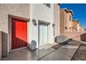 Exterior view of the side of the home with a red front door and small yard at 4052 Rocky Beach Dr, Las Vegas, NV 89115
