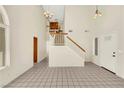 Bright foyer with tiled flooring, high ceilings, a staircase with wood railing, and modern chandeliers at 409 Rutherford Cir, Las Vegas, NV 89123