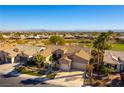 Beautiful aerial view of single-story home featuring well-manicured lawns, desert landscaping and a three car garage at 4796 Riva De Romanza St, Las Vegas, NV 89135