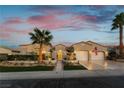 Charming single story home with desert landscaping, tall palm trees, and a paved walkway to the front door at 4796 Riva De Romanza St, Las Vegas, NV 89135