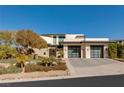 Modern home with a manicured front yard, desert landscaping, and a two-car garage at 4918 Summit Overlook Dr, Las Vegas, NV 89135
