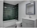 Modern bathroom features a tub with sleek tiling, new vanity, and stylish mirror at 501 National St, Henderson, NV 89015