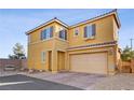 Two-story home featuring a front-facing two car garage, gravel landscape, and neutral paint scheme at 6121 Sinatra Sands Ct, Las Vegas, NV 89130