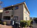 Exterior view of a condo unit with beige stucco, red tile roof and small patio area at 7200 Pirates Cove Rd # 1025, Las Vegas, NV 89145