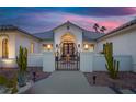 Close up of the front entry featuring a custom metal gate and desert landscaping at 8211 Windsor Crest Ct, Las Vegas, NV 89123