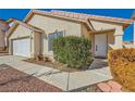 Single story home with neutral stucco, tile roof, rock landscaping, and a two car garage at 8728 Honey Vine Ave, Las Vegas, NV 89143
