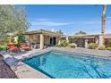 Gorgeous backyard featuring a refreshing swimming pool, outdoor kitchen, and covered patio area at 11099 Moonlight Fire Ct, Las Vegas, NV 89135