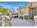 Inviting front porch featuring modern furniture, stone accents, and manicured bushes at 11099 Moonlight Fire Ct, Las Vegas, NV 89135