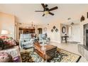 Cozy living room with neutral walls, ceiling fan, and view into the dining area and kitchen at 11845 Tevare Ln # 2069, Las Vegas, NV 89138