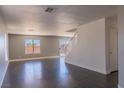 Spacious living room with wood floors, neutral paint, bright windows and sliding glass door at 1416 Swanbrooke Dr, Las Vegas, NV 89144