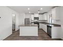 Well-designed kitchen features stainless appliances, an island, and white cabinets for ample storage at 1705 Desert Path Ave, North Las Vegas, NV 89032