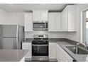 Modern kitchen with stainless steel appliances, light cabinets, and stone countertops at 1705 Desert Path Ave, North Las Vegas, NV 89032