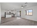 Open-concept living area with durable wood flooring, plush carpet, and sliding glass doors to the backyard at 1705 Desert Path Ave, North Las Vegas, NV 89032