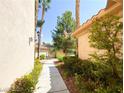 Serene walkway lined with lush greenery and trees, leading to a glimpse of the community's manicured landscape at 2050 W Warm Springs Rd # 2922, Henderson, NV 89014