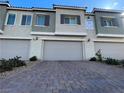 Townhome garages with paved driveway and desert landscaping at 3669 Canis Minor Ln # 15101, Henderson, NV 89052