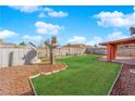 Large backyard offers green grass and gravel landscaping; perfect for outdoor entertaining or relaxation with a covered area at 3920 Geist Ave, Las Vegas, NV 89115
