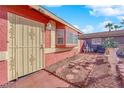A cozy front entrance to the home, showing the painted exterior and brick-lined walkway and decorative garden at 3920 Geist Ave, Las Vegas, NV 89115