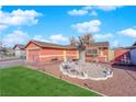 Well-manicured front yard with green grass, gravel, and a decorative tree; providing great curb appeal at 3920 Geist Ave, Las Vegas, NV 89115
