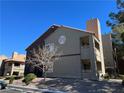 Exterior view of the building showcasing a stucco facade, terracotta tiled roof, and assigned unit numbers above the windows at 5024 S Rainbow Blvd # 203, Las Vegas, NV 89118
