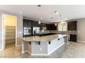 Modern kitchen featuring dark cabinetry, stainless steel appliances, and a large island at 5646 Sophie Belle Ave, Las Vegas, NV 89131