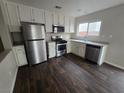 Updated kitchen with stainless steel appliances, white cabinets, and dark hardwood flooring at 6143 Windmill Island Ave, Las Vegas, NV 89139