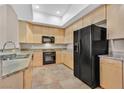 Bright kitchen featuring light wood cabinetry, granite countertops and black appliances at 62 E Serene Ave # 114, Las Vegas, NV 89123